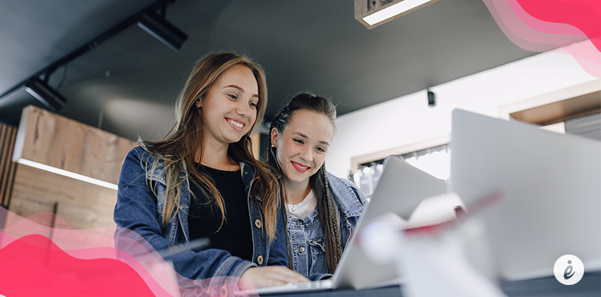 dos mujeres mirando computador sonríen feria de cantón